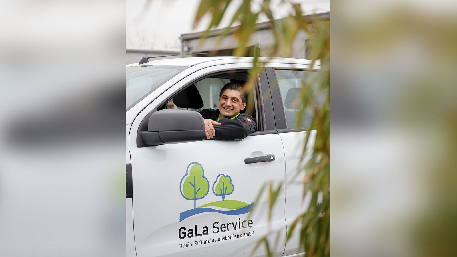 GaLa Service Inklusionsbetrieb Ein Mann mittleren Alters sitzt am Steuer eines weißen Kastenwagens. Auf der Fahrertür ist des Logo der GaLa Service gGmbH zu sehen.