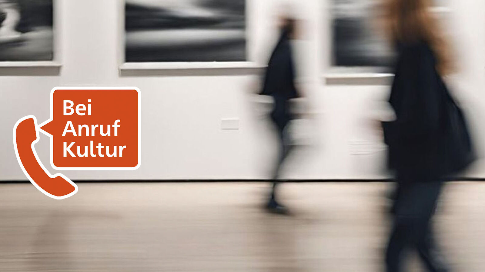 Kulturtelefon Die Grafik zeigt den Saal eines Museuums mit großen Fotografien an den Wänden. Personen laufen daran vorbei. Das Bild ist unscharf. Darüber sind am linken Bildschirmrand ein Telefonhörer und eine Sprechblase montiert. In der Sprechblase steht: "Bei Anruf Kultur"