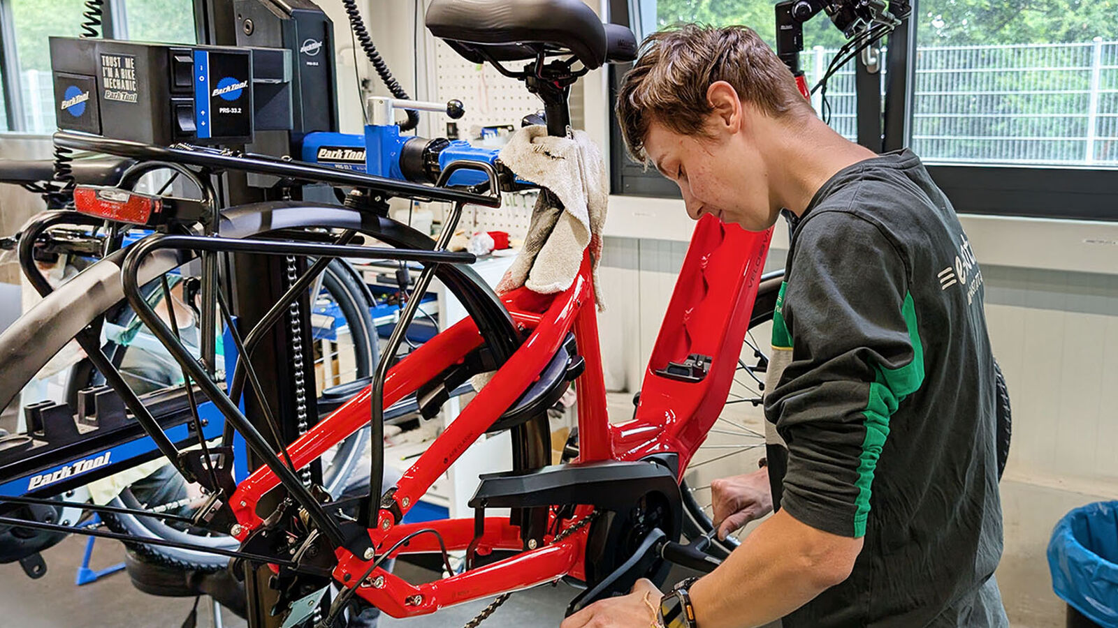 Fahradmechanikerin Viola Blöchle montiert ein rotes E-Bike.