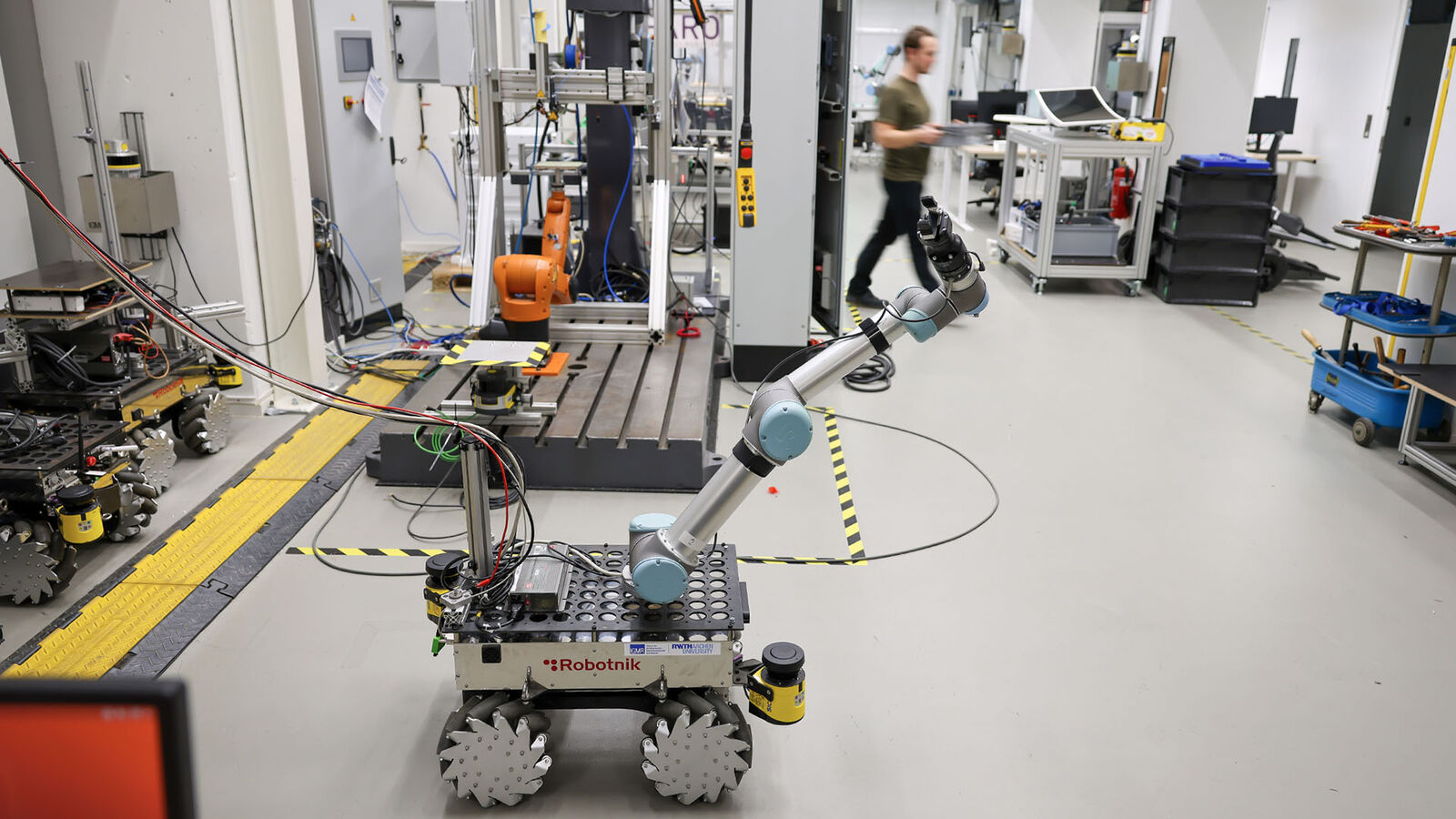 Fahrender Cobot Ein auf ein kleines Gefährt montierter Cobot steht im Institut auf dem Flur.