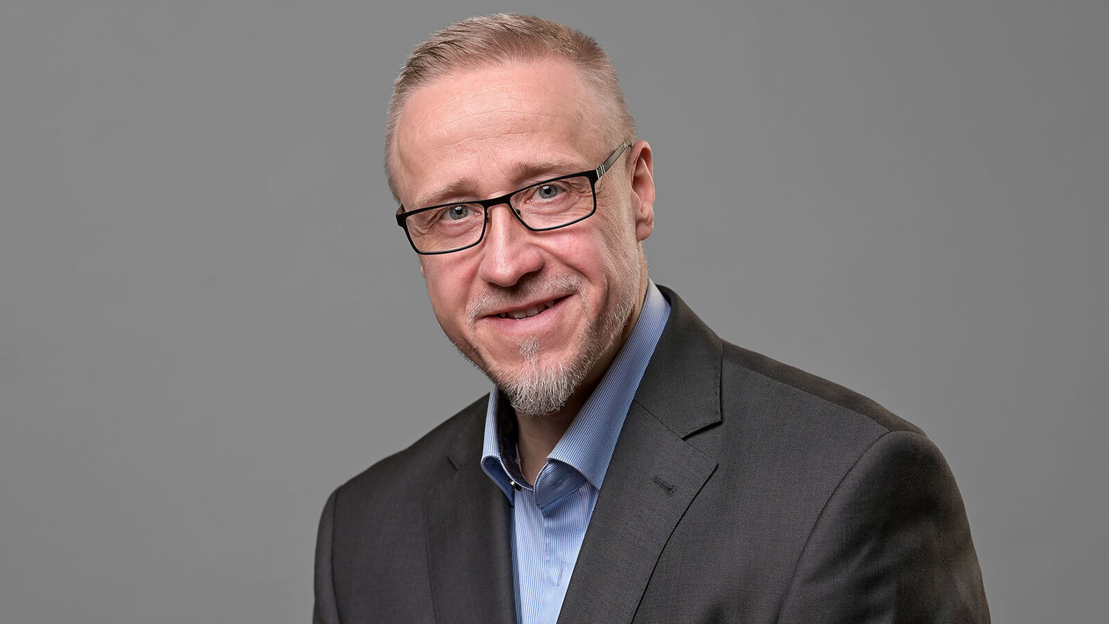 Inklusionsbeauftragter Said Frank Becker Porträtbild des Inklusionsbeauftragten Said Frank Becker vor grauem Hintergrund.