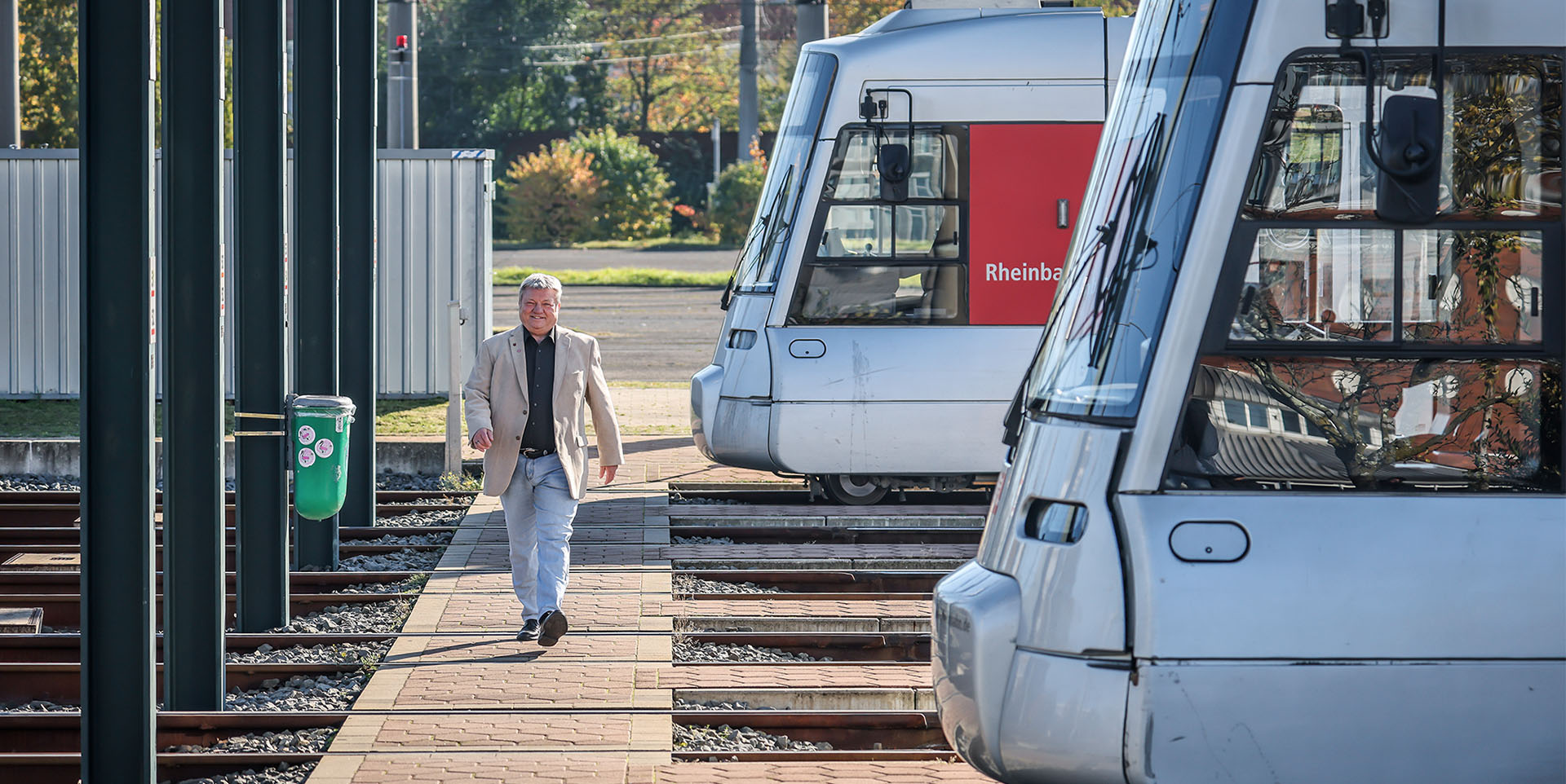 Brings Brings läuft im Straßenbahndepot an einigen geparkten Straßenbahnen vorbei