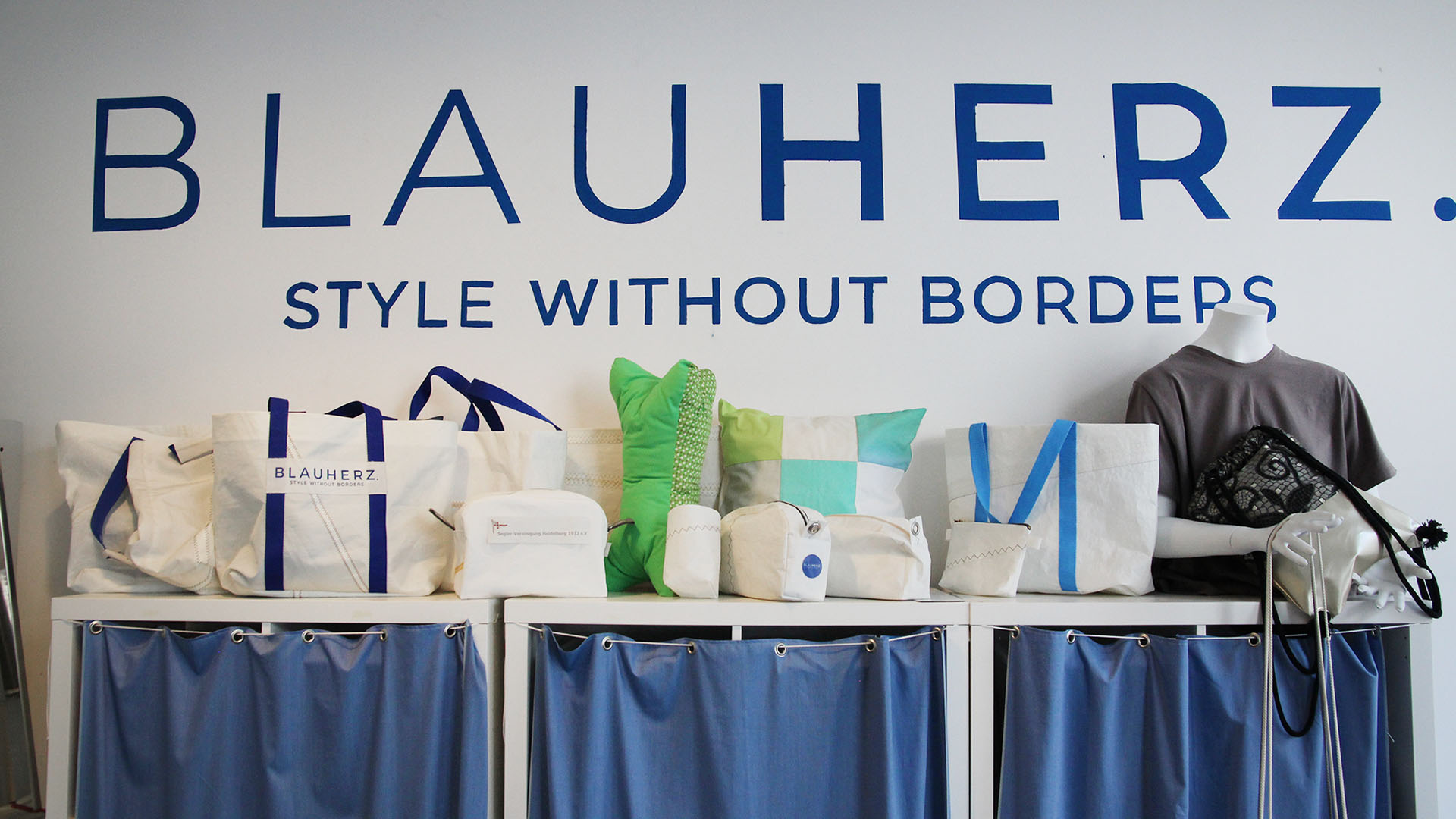 Das Foto zeigt ein Regal mit der aktuellen Taschenkollektion. Darüber steht der Schriftzug „Blauherz“.