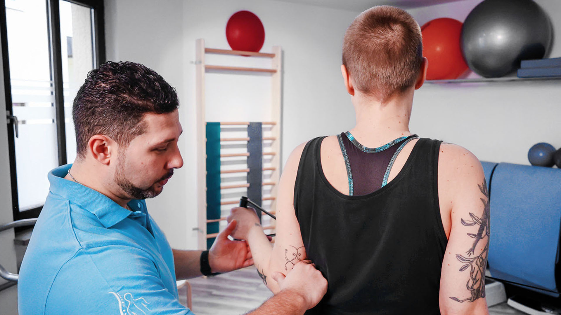 Dimitrios Belokas mit einer Patientin im Sportraum der Praxis