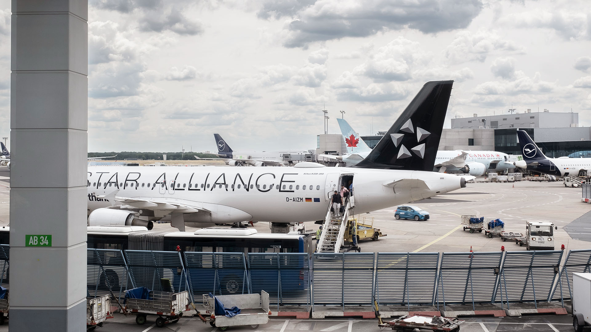 Der Blick fällt durch ein großes Fenster auf ein Terminal mit parkenden Flugzeugen.
