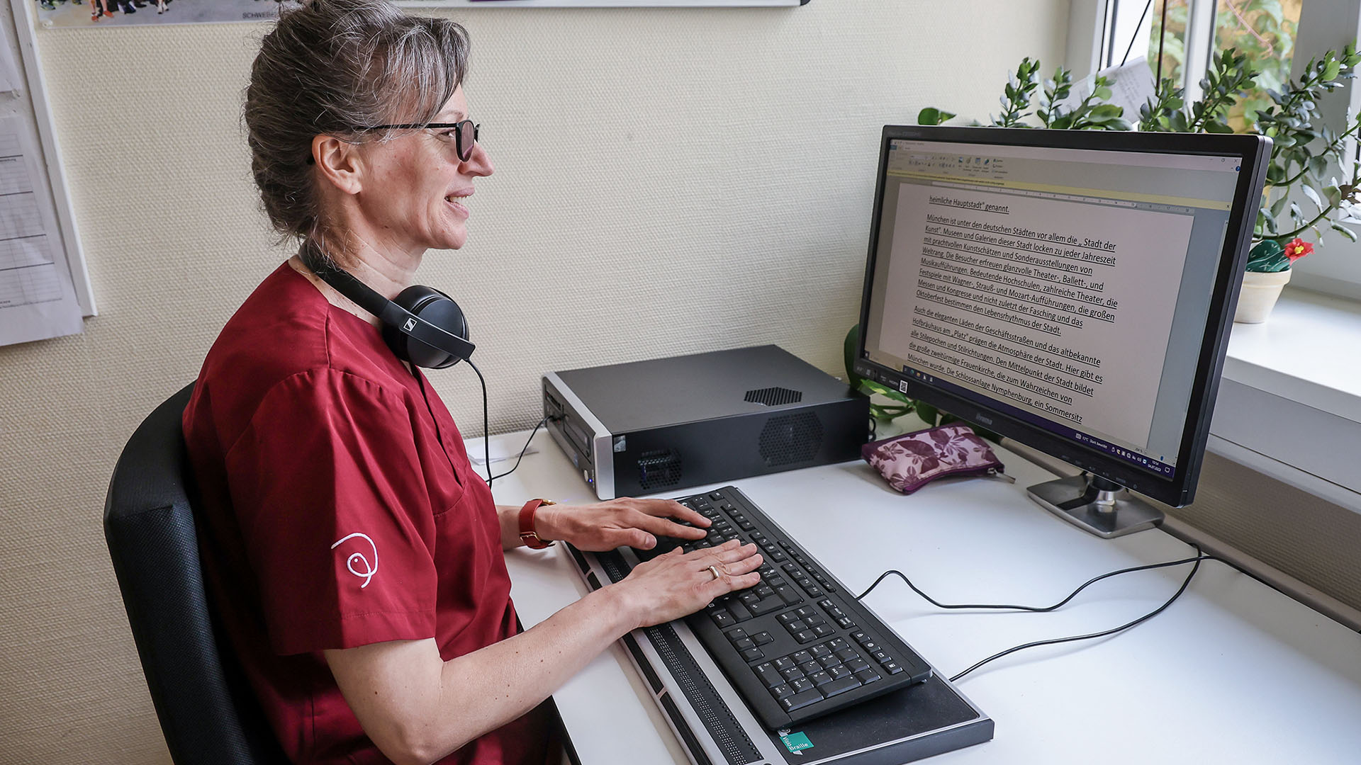 Agniezka Bartoszek liest am PC mit Braillezeile.