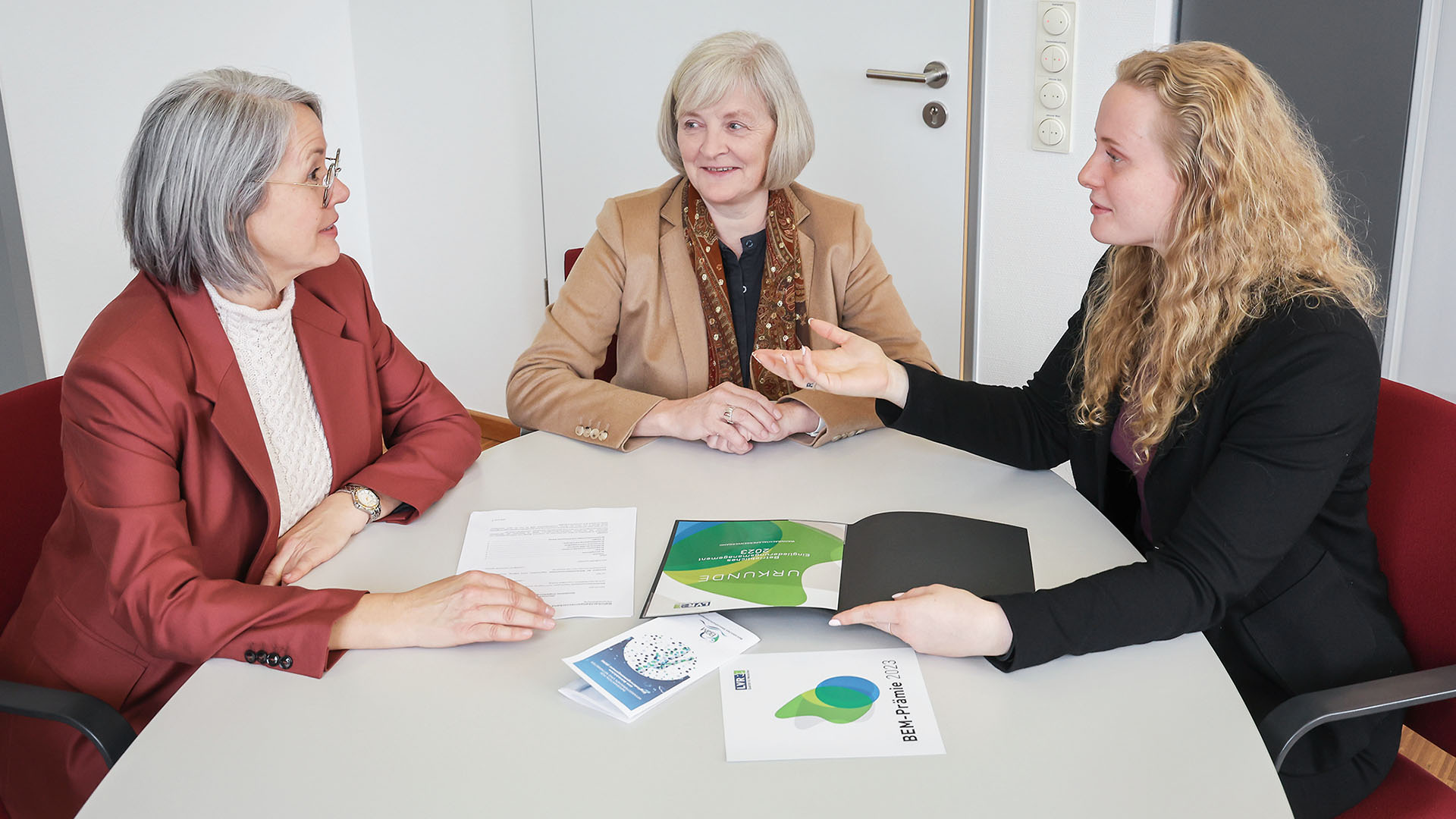 Susanne Hoffstadt, Ludgera Decking und Alina Süß sitzen an einem Tisch.