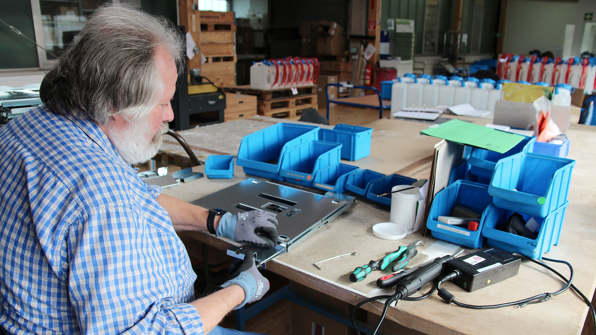 Ein Mitarbeiter bei der Montage an einer Werkbank.
