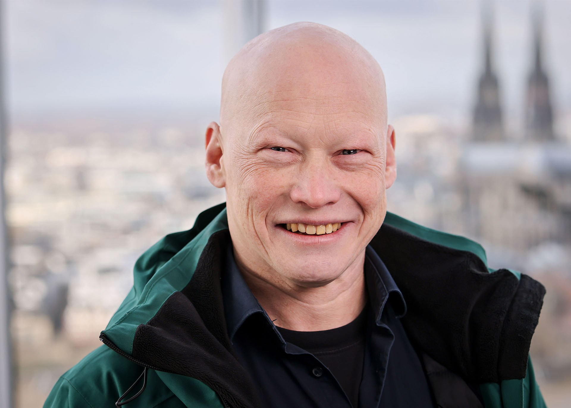 Das Foto zeigt Swen Windhaiser, im Hintergrund ist der Kölner Dom zu sehen.