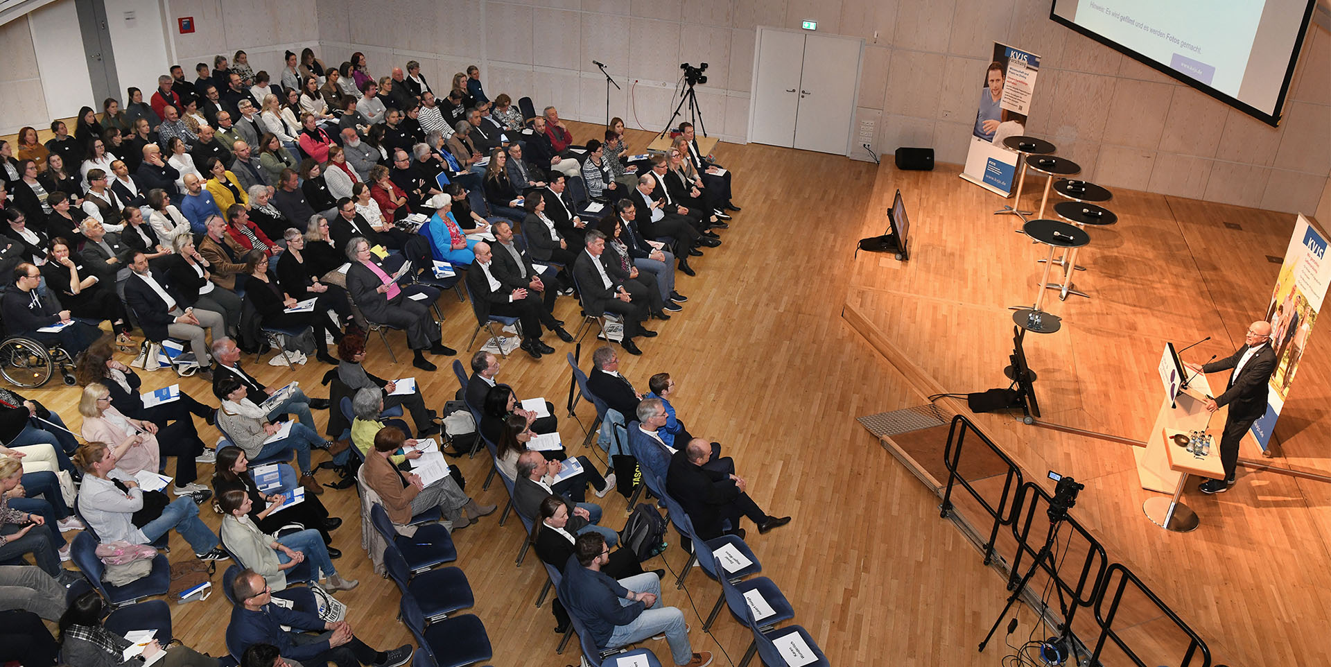 Draufsicht des Fachtags mit Podium und Publikum