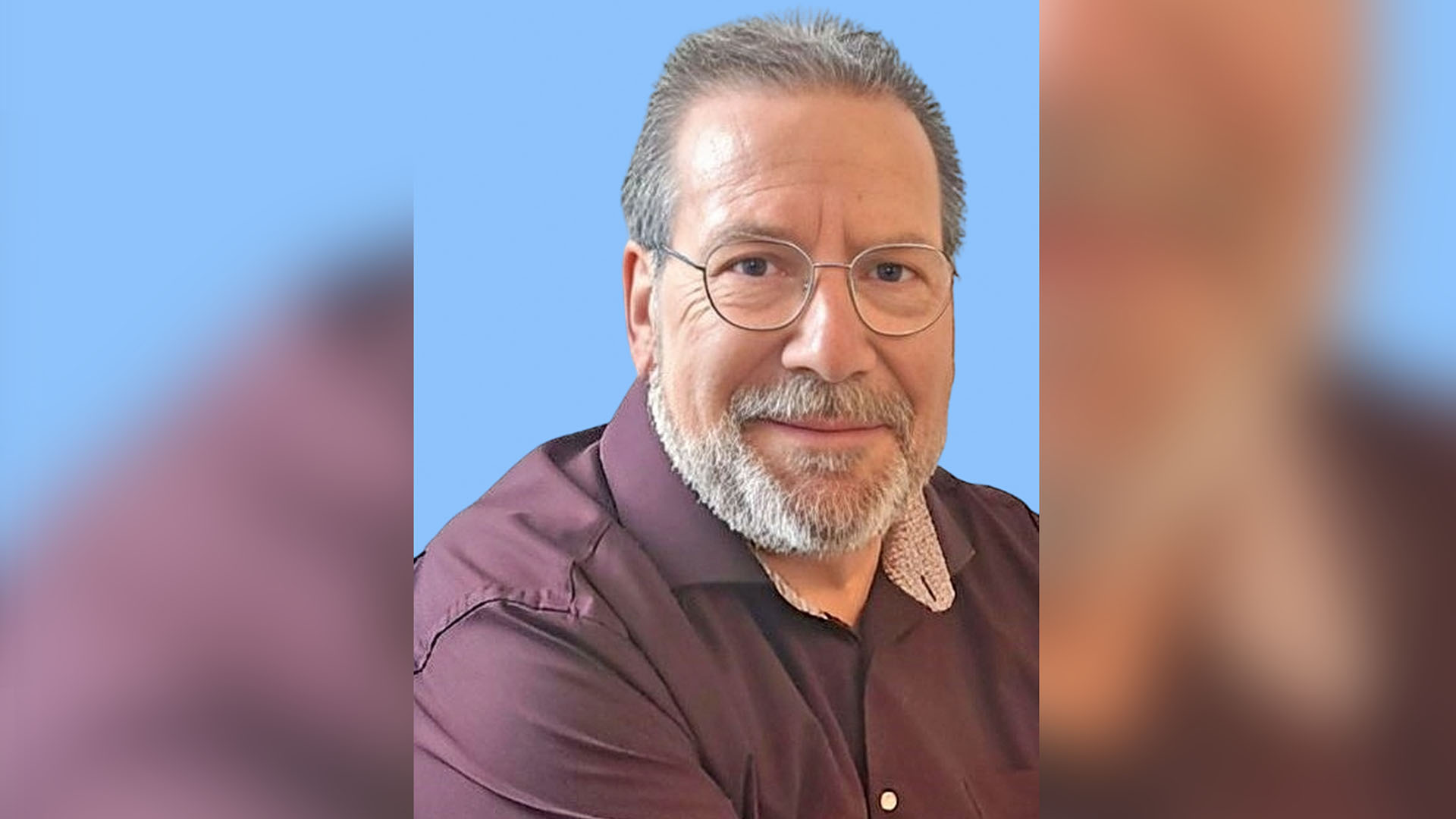 Porträtbild des EAA-Beraters Horst Seim vor blauem Hintergrund.