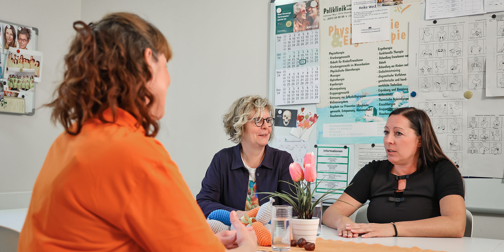 Gespräch Cathleen Kaltofen und Ingrid Wollschläger Cathleen Kaltofen und Ingrid Wollschläger stehen einander zugewandt am Empfang in der Praxis.