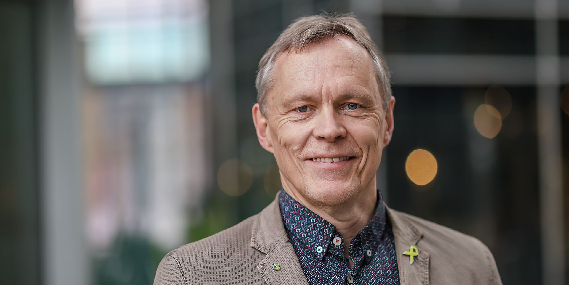 Porträt von Hajo Oetmann, ein großer kräftiger Mann Anfang 60 mit blonden kurzen Haaren im Cordjacket.