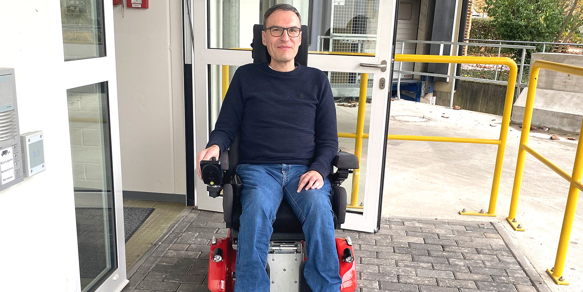 Schäffers in einem E-Rollstuhl vor der Eingangstür