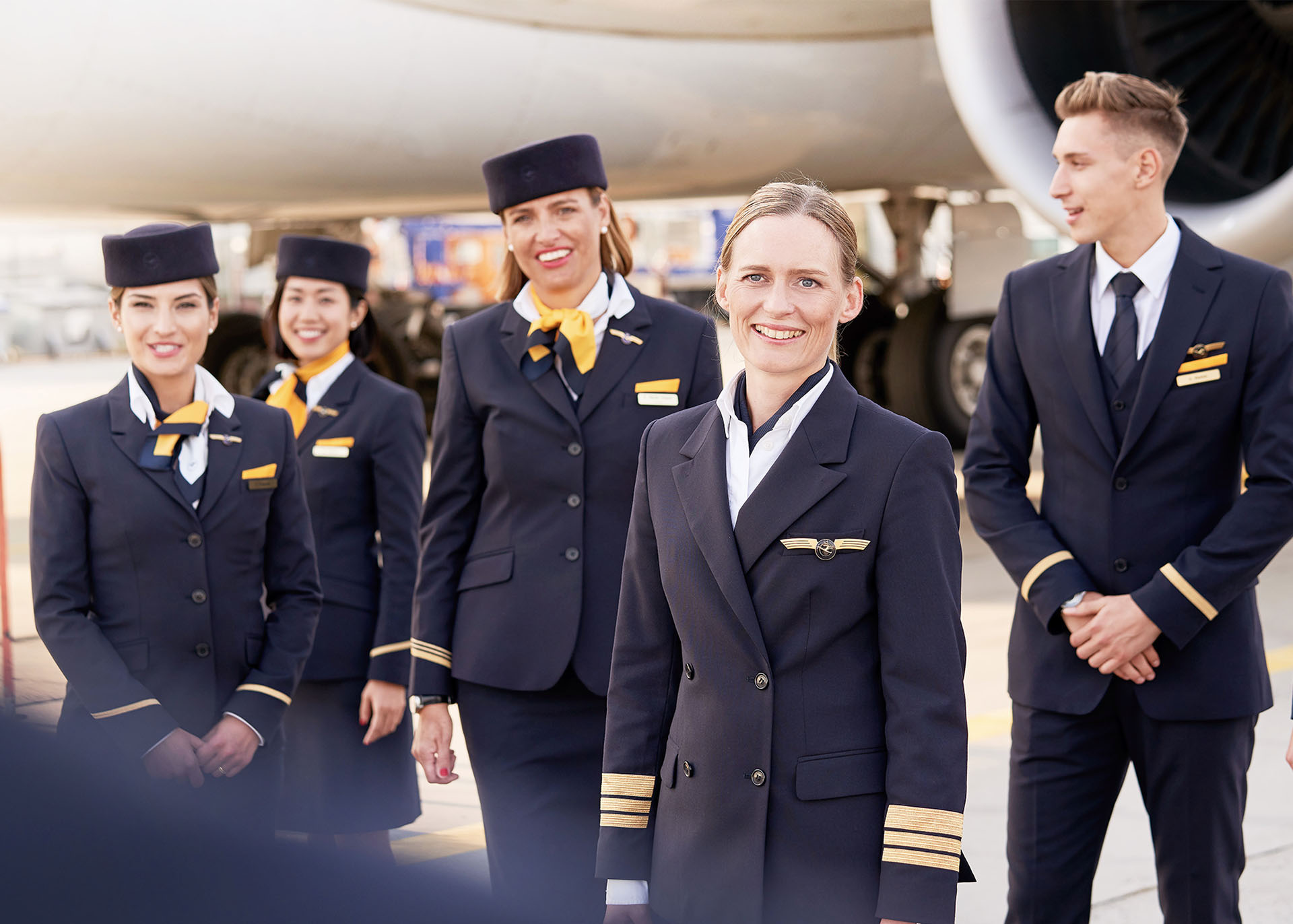 Gruppenbild einer Flugzeugbesatzung am Flughafen vor einem Flugzeug.