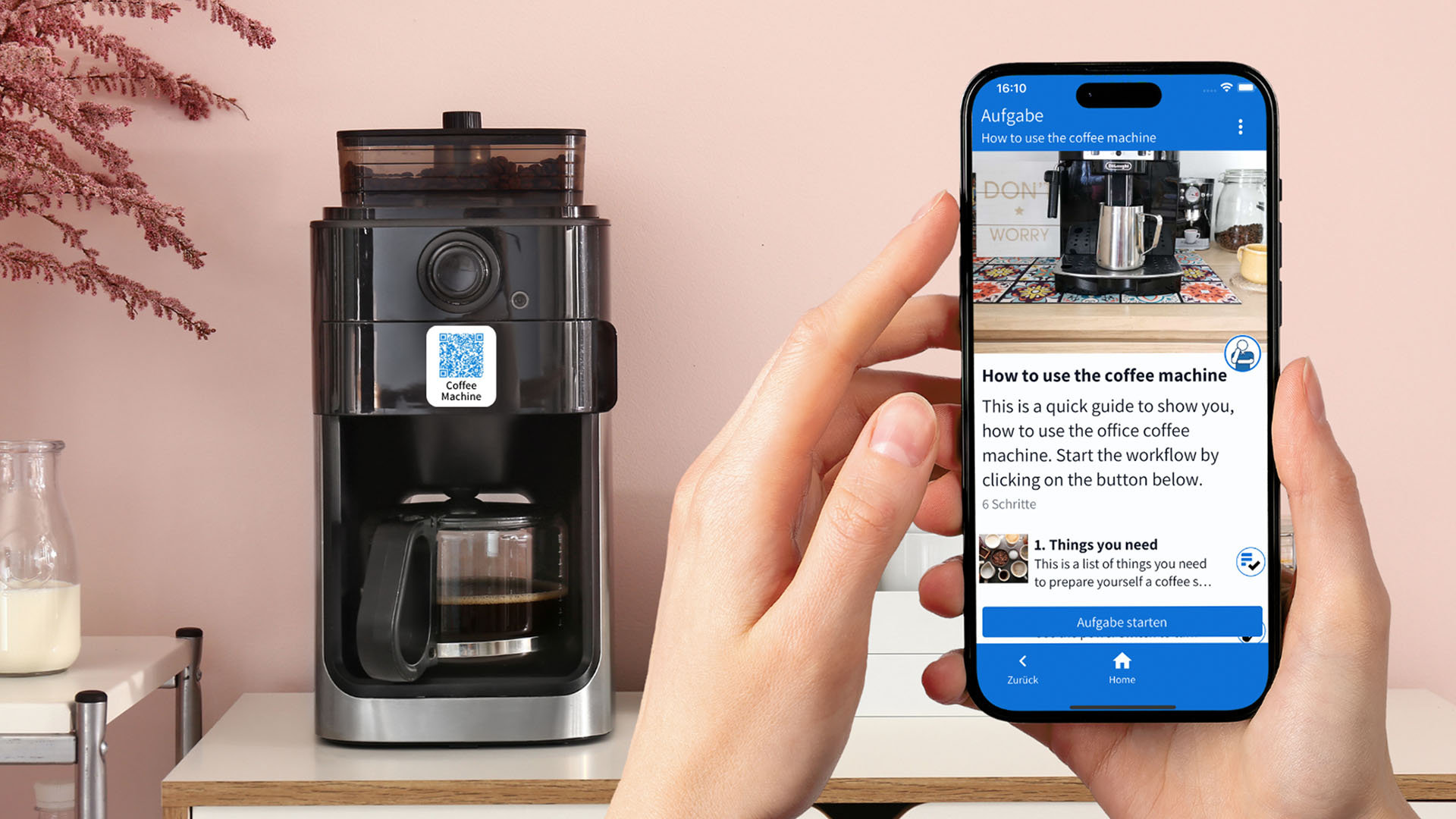 Smartphone mit einer Abbildung, wie die Kaffeemaschien bedient wird. 