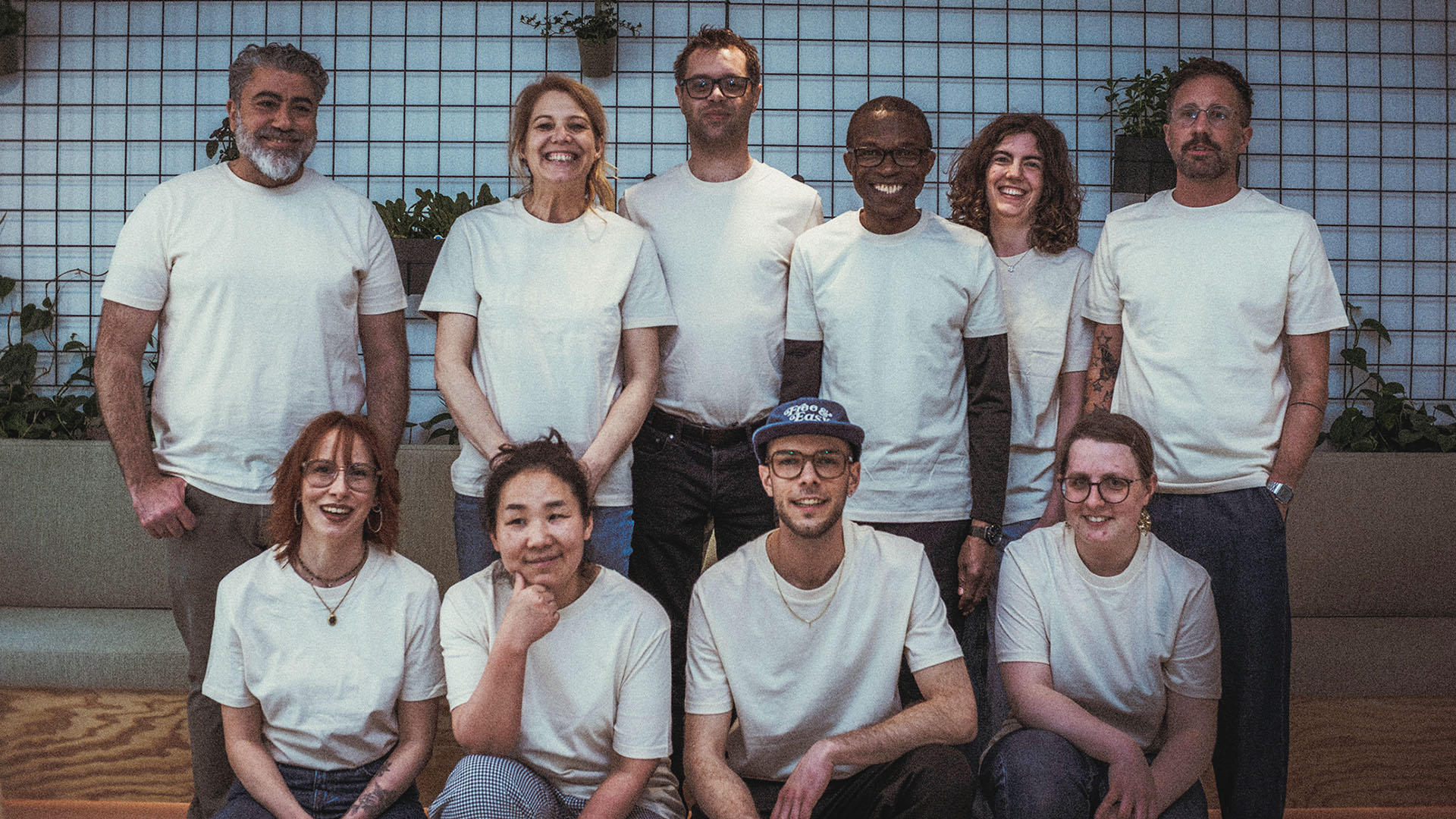Gruppenfoto des Gastroteams: Vier junge Menschen knien in der ersten Reihe. Dahinter stehen vier Männer und zwei Frauen. Alle tragen einheitliche weiße T-Shirts.